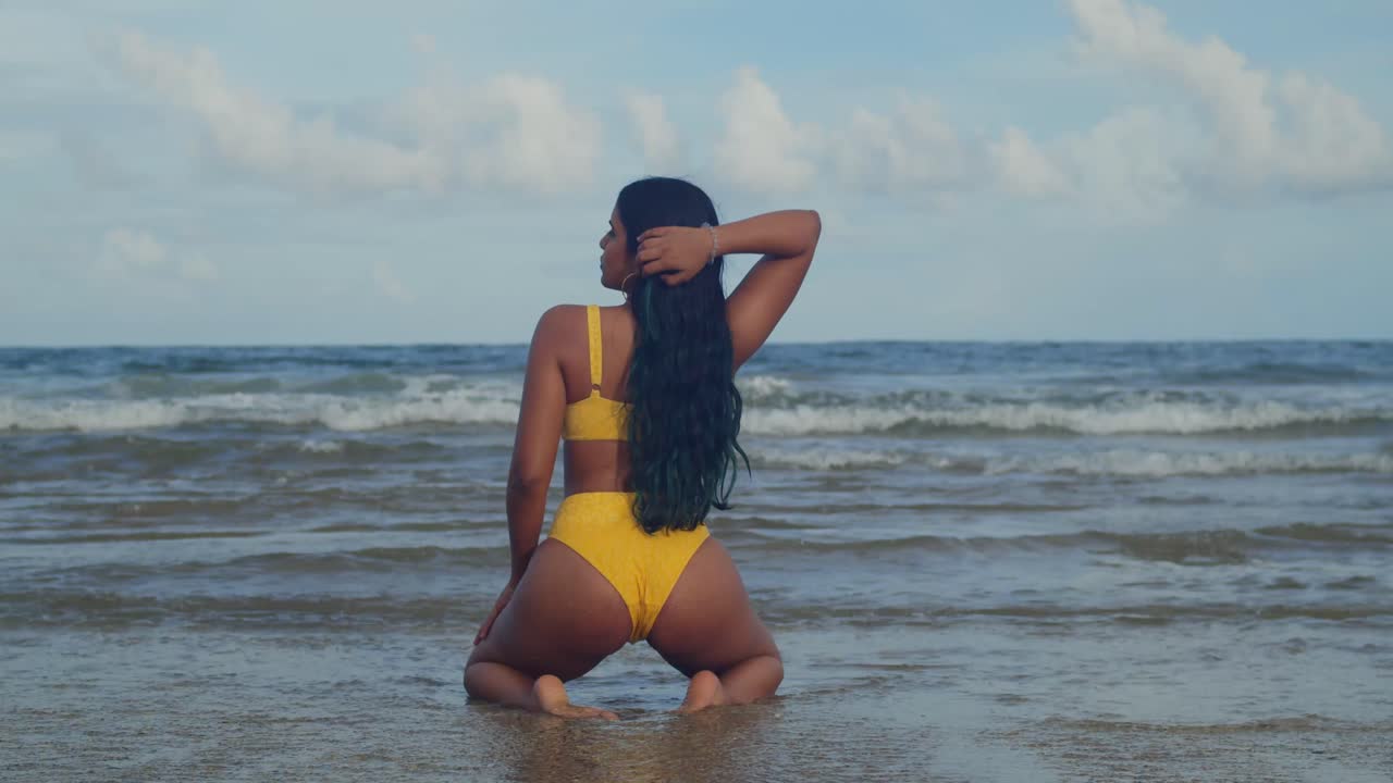 Una donna in bikini giallo che si rilassa su una spiaggia tropicale