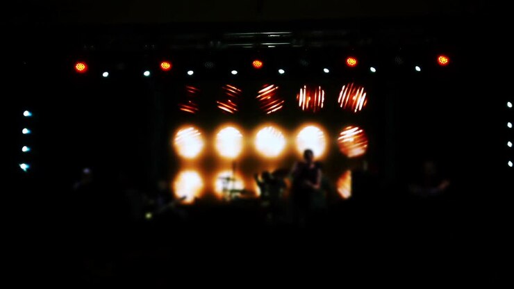 Concerto sul palco. Folla di persone e musicisti sulla scena. Fuori fuoco