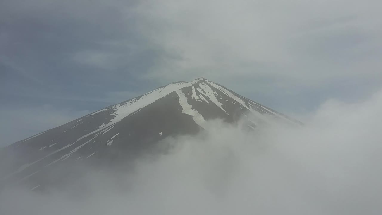 Mount Fuji through the Clouds and obove the Clouds. Clouds opden like a curtain.