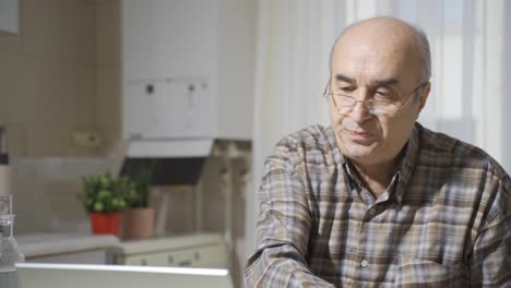 Thoughtful-old-man-working-on-laptop.