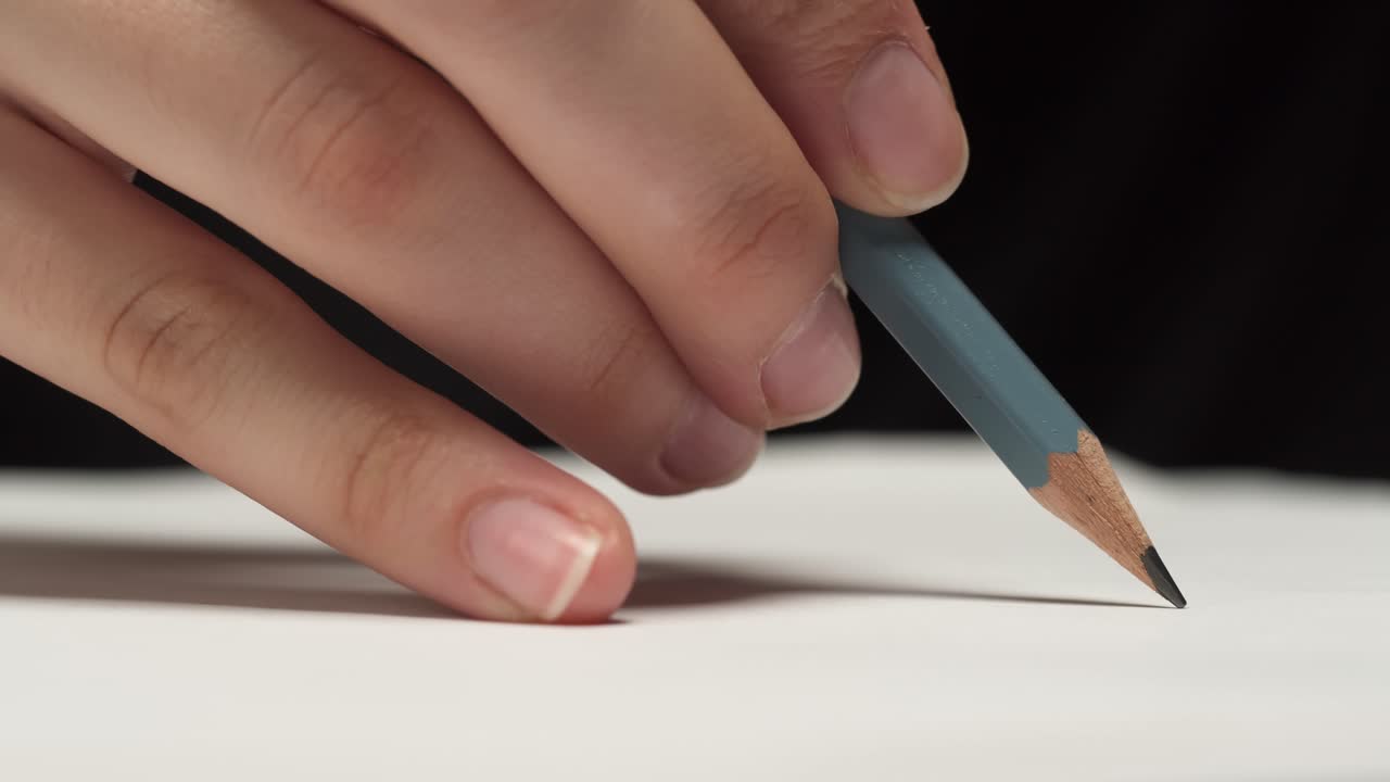 Primo piano di una mano che traccia una linea con una matita su carta
