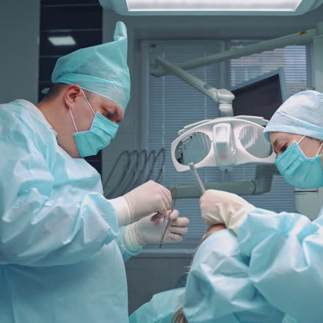 professional stomatologist treats patients teeth with the help of an assistant in clinic. dentist man with a nurse in medical uniform at work on the dental equipment background. dental check up.