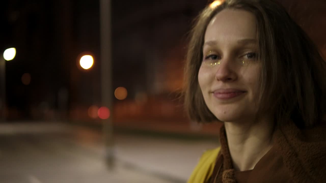 grupo de jóvenes y alegres sentados junto al fuego en la playa por la noche, asando salchichas y tocando la guitarra
