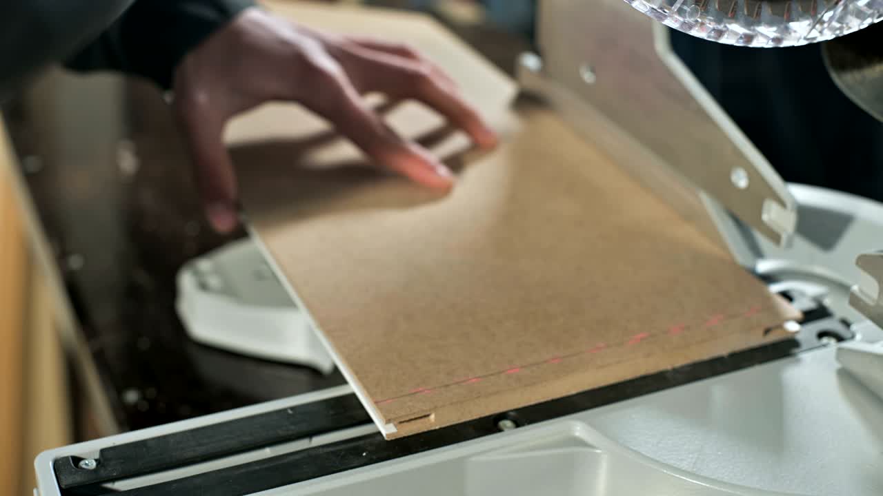un joven carpintero instala una pieza de madera en una sierra circular
