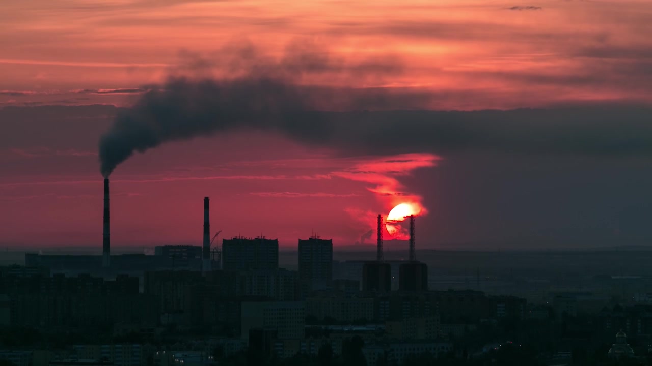 Aerial view with sunrise over the city center with smoking pipes and central business district timelapse from rooftop, Nur-Sultan city, Kazakhstan, Central Asia