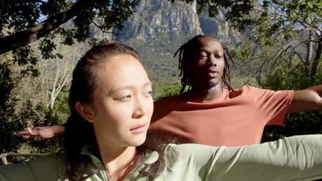 happy diverse couple practicing yoga and smiling in sunny garden, slow motion