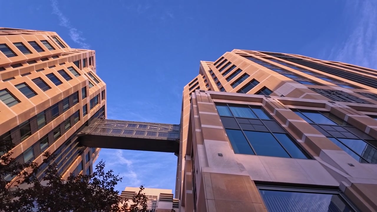 Arquitectura modernista del Edificio Federal Ronald V. Dellums y el Tribunal de los Estados Unidos en Oakland, California, con una pasarela elevada que conecta dos torres contra un cielo azul claro al atardecer