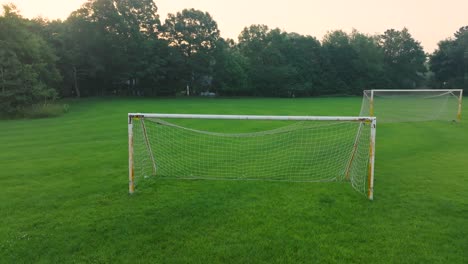 a soccer net sitting in an empty soccer practice field