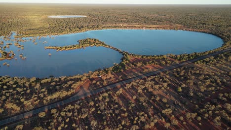 aerial approaching shot of lake in semi-desert area of western australia at sunset time