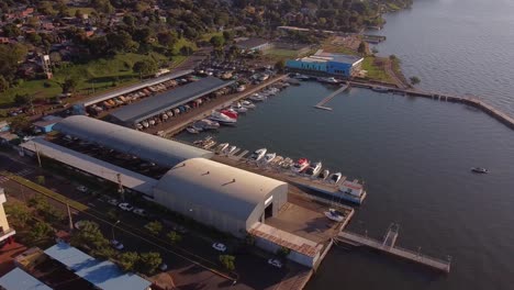 circling aerial drone view of a harbour with small and large boats or yacht at pira pytá in posadas argentina