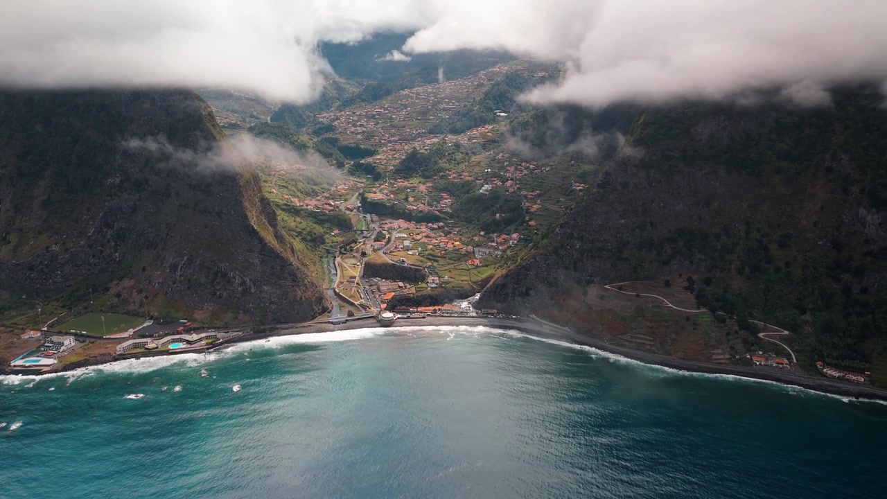 Descubra as paisagens deslumbrantes de São Vicente, Madeira, de uma perspectiva de drone de alta altitude. Esta filmagem aérea captura a costa, vales verdes e montanhas vulcânicas