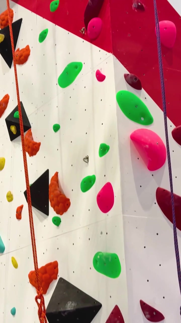 Farbenfrohe Kletterwand mit verschiedenen Haltestellen