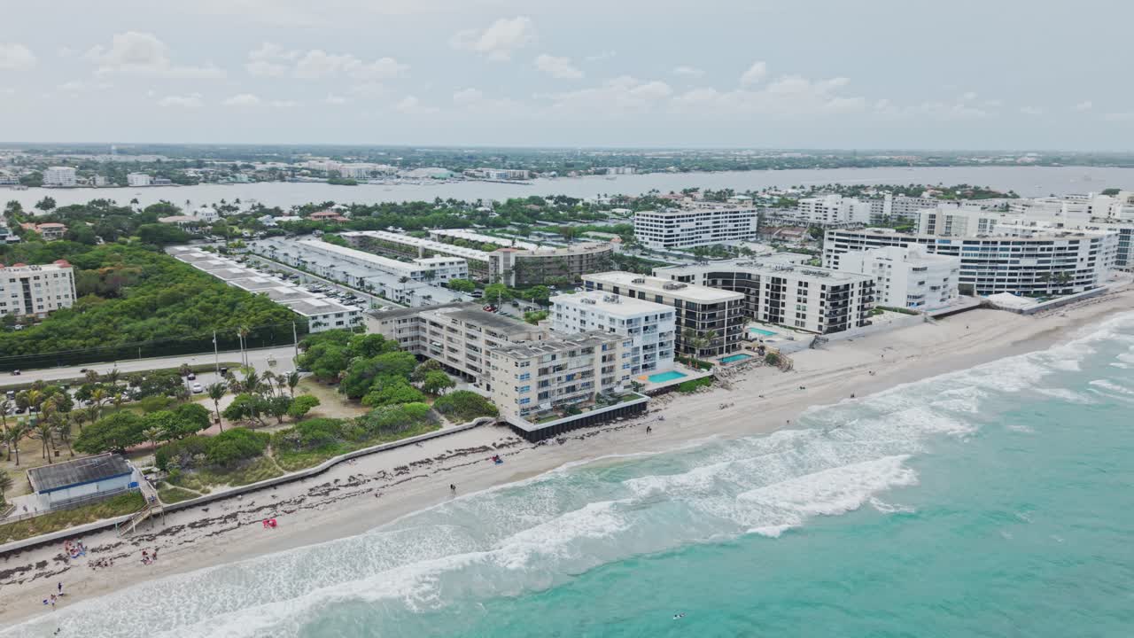 Aerial: turquoise water of Atlantic Ocean with cloudy weather during the day in West Palm Beach, Florida, USA, orbit drone shot