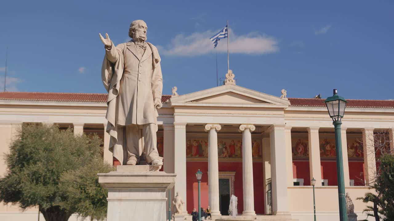 Statua ed edificio storico a Panepistimio, giornata limpida, atmosfera tranquilla.