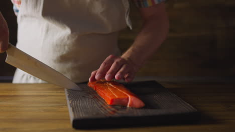 el empleado en delantal corta delicioso salmón ahumado fresco