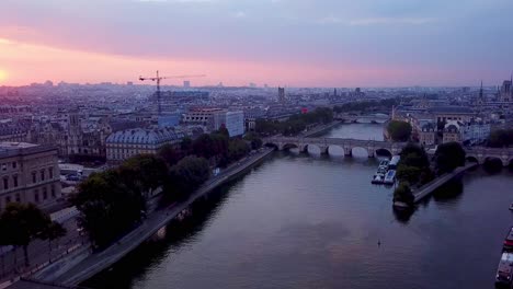 backwards flying drone from ile de la cite and pont neuf to pont des arts bridge in sunrise time