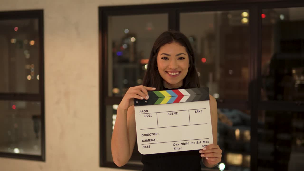 hermosa joven mujer asiática feliz sonriendo clapperboard cine casa