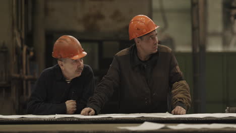 factory workers reviewing plans