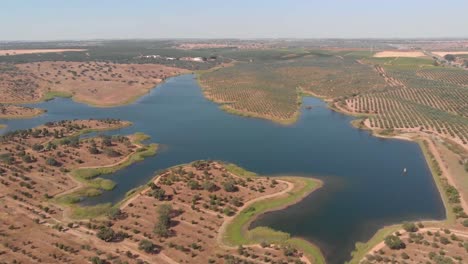 aerial view of natural lake with beautiful desert landscape during sunny day in beja,portugal