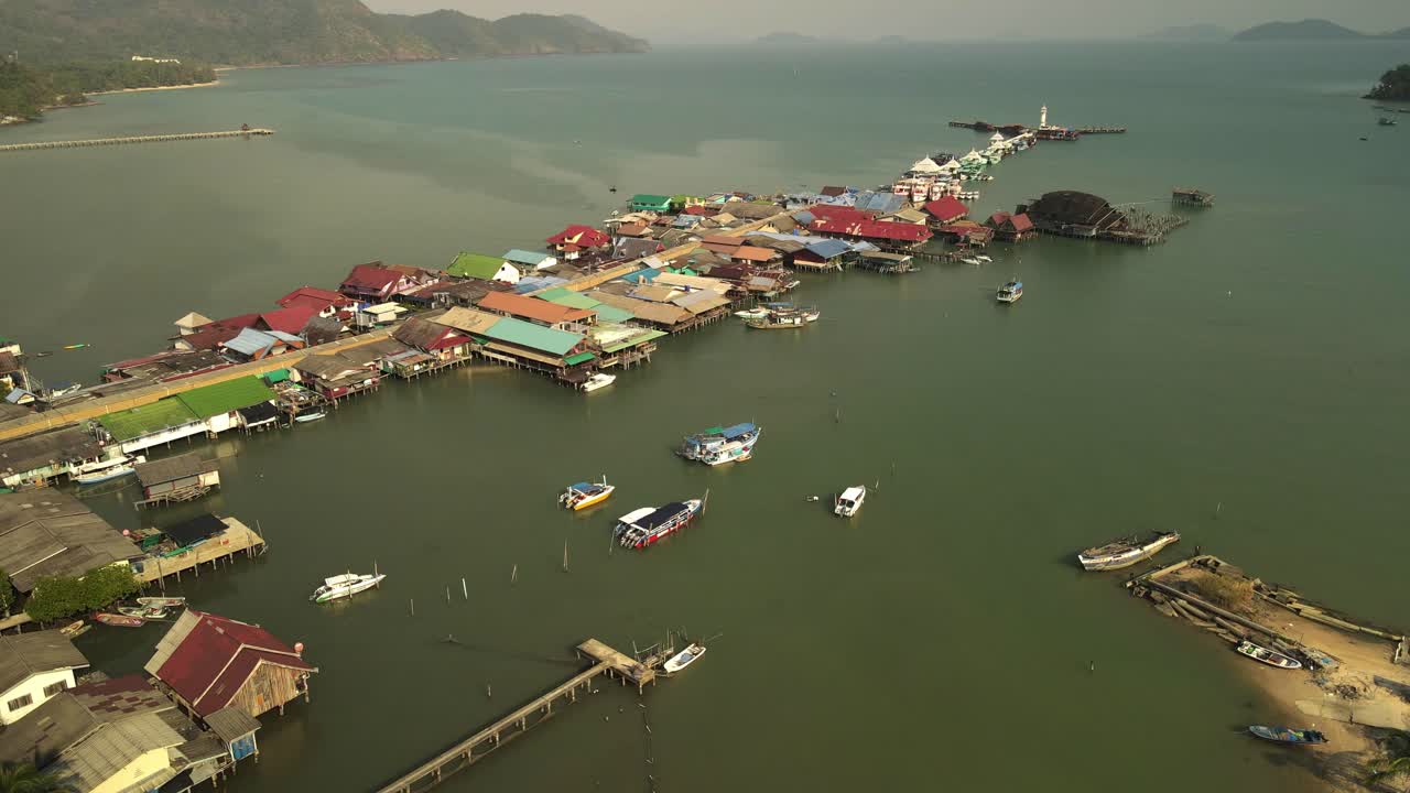 Slow downward aerial tilt up of the Bang Bao fishing pier on the island of Koh Chang, Thailand.