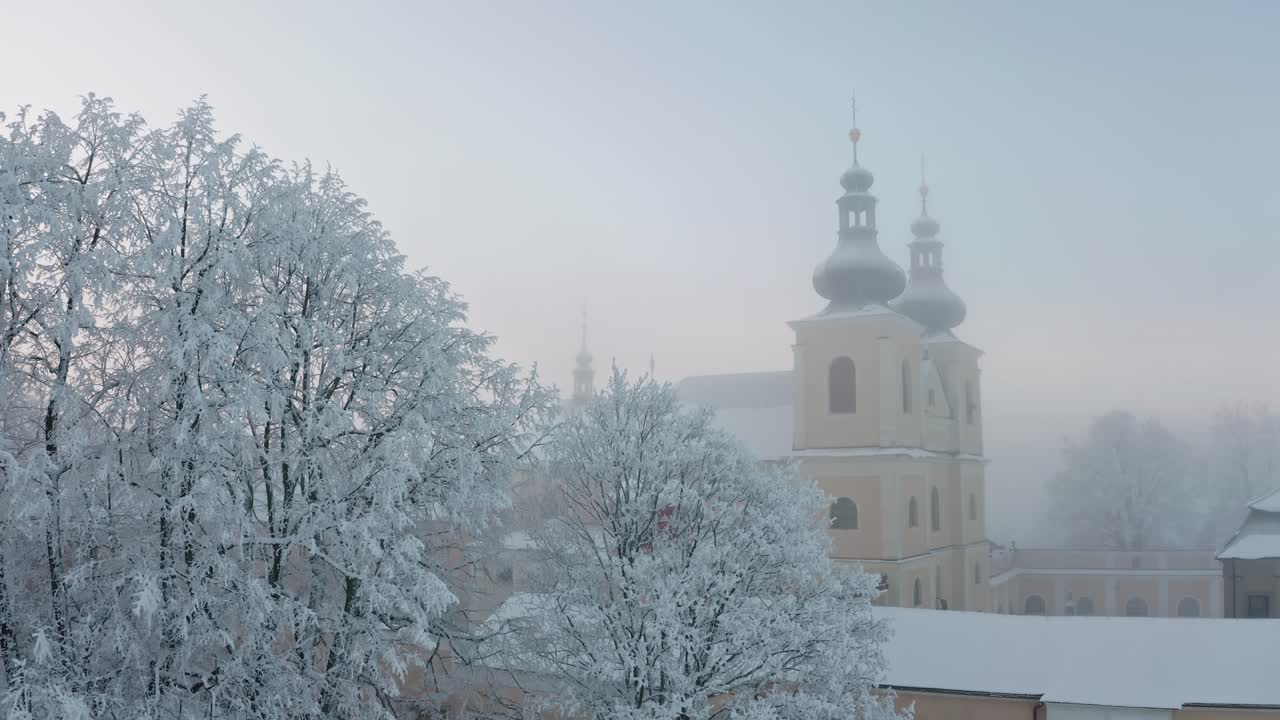 Christian monastery on top of the hill in fog in winter from drone