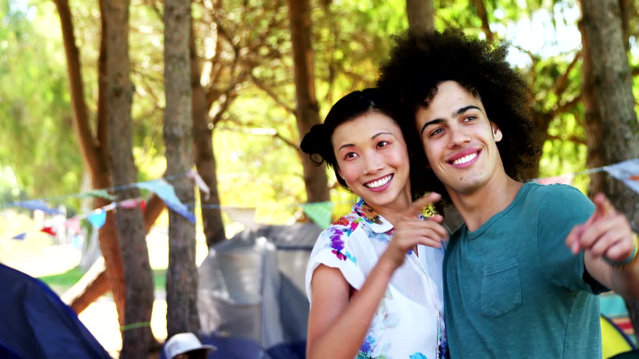 Couple embraching and pointing at distant in park 4k