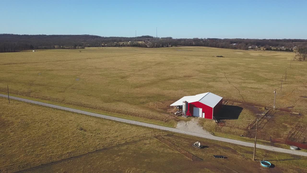 Vista aerea a bassa quota di un piccolo fienile su un campo aperto