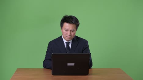 녹색 배경에 성숙한 일본 사업가