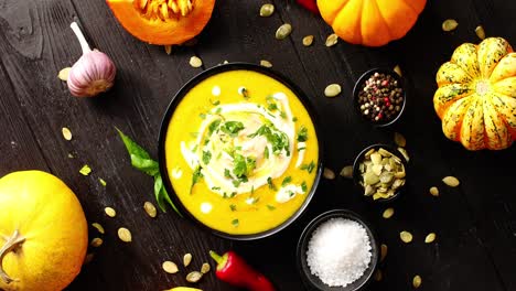 yellow fresh pumpkin soup surrounded by spices and seeds