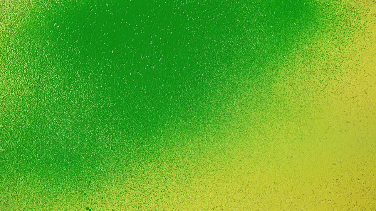 Grüne Sprühfarbe bedeckt gelbe Oberfläche