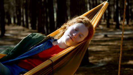 woman sleeping on a hammock in the forest 4k