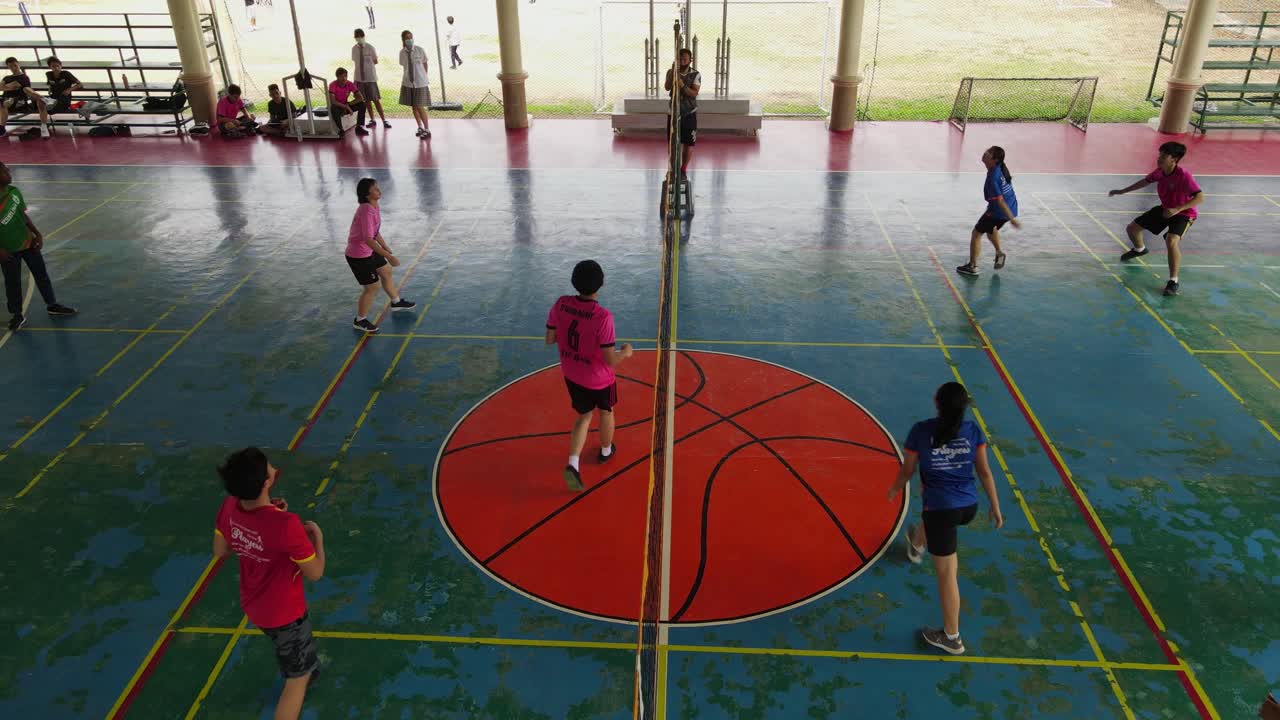Volleyball game during a Physical Education class; aerial footage of a Physical Education class, serve, toss, setup, strike, defend.