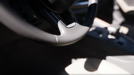 close up of a black leather steering wheel in a car