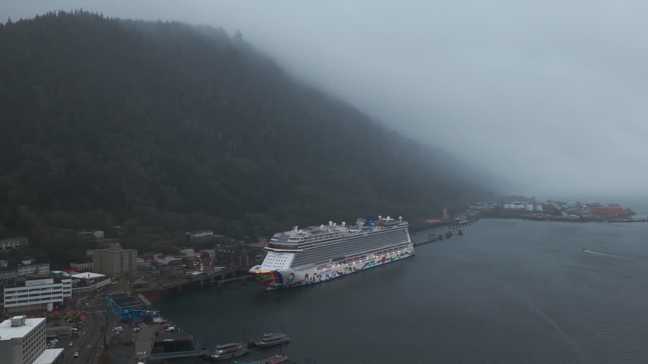 Aerial wide panning shot of a cruise ship docked at the terminal during rainy weather in Juneau, Alaska. 4K