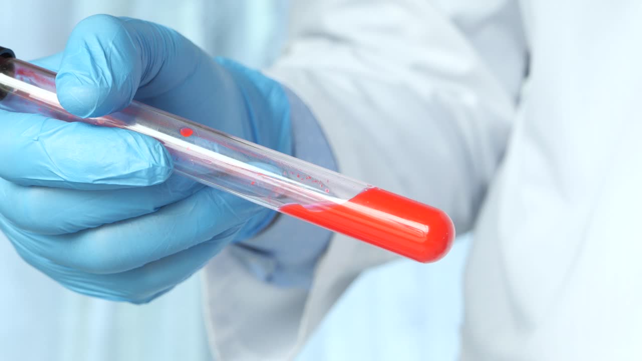 Lab Technician Holding a Test Tube with Red Liquid