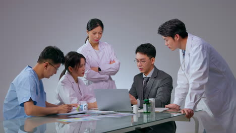 professional group of doctors talking to pharmaceutical medical sales representatives about drug services