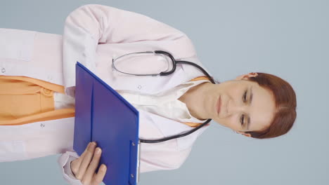 Vertical-video-of-The-doctor-examining-the-paperwork-is-thoughtful.