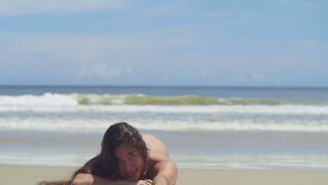 a woman with flowing locks embraces the sun and sea on a tropical beach in a thong bikini with ocean waves in the background