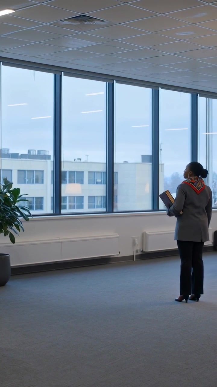Video vertical: Mujer con pañuelo y bloc entrando a la oficina, yendo a las ventanas, revisando y regresando, con espacio para texto.