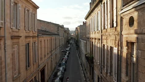 Calle-Antigua-Clásica-En-Burdeos,-Francia,-Avance-Aéreo-Al-Atardecer-Con-Sunflairs