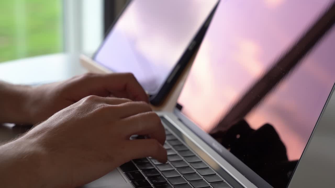 The concept of remote work. Close-up of male hands typing on the keyboard in search of information. A freelance copywriter is working on a project.