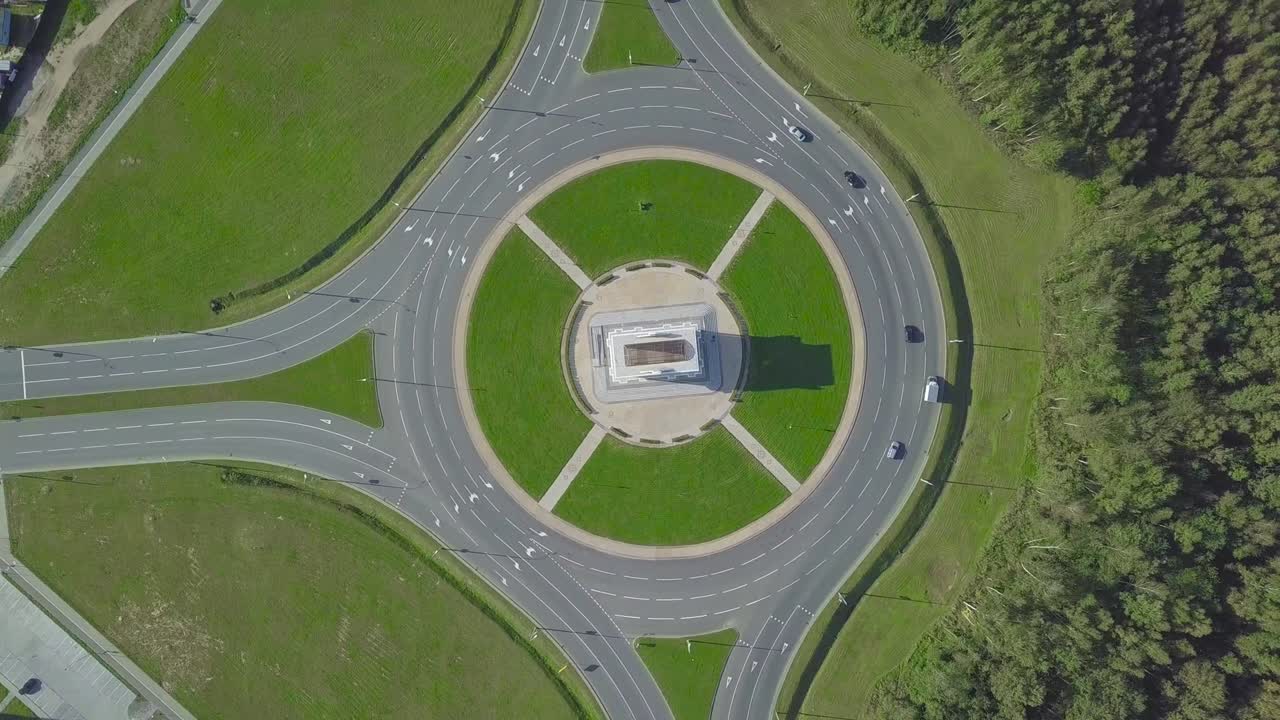 камера дрона вращается вокруг кругового кольца на городском проспекте.