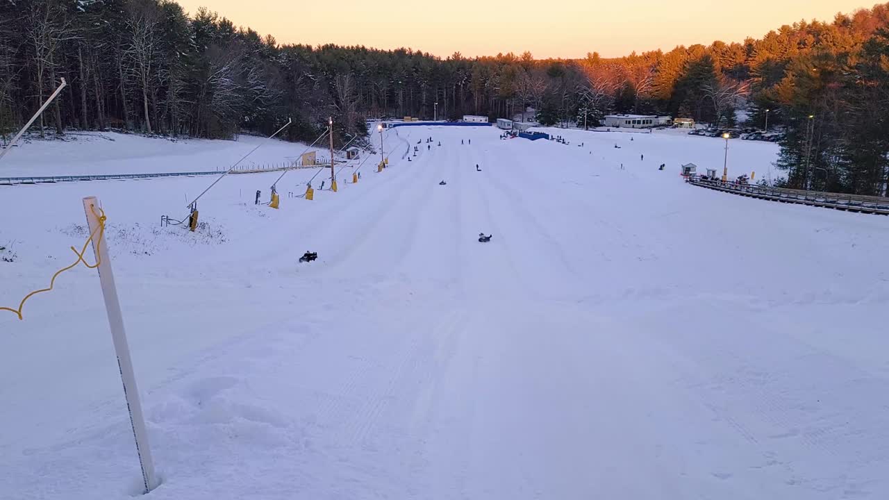 Persone che si divertono a fare tubing invernale in discesa al Nashoba tubing park, Massachusetts.