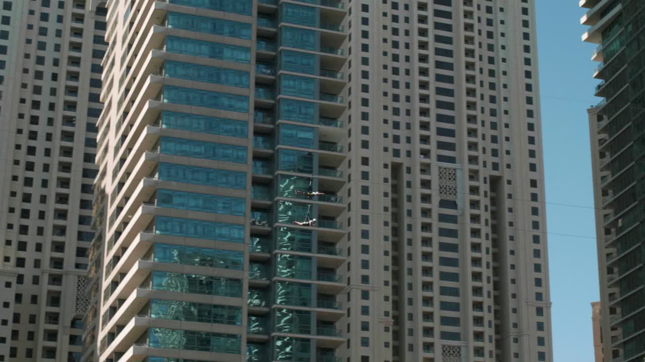 tirolesa volando entre torres de rascacielos, divirtiéndose en vacaciones