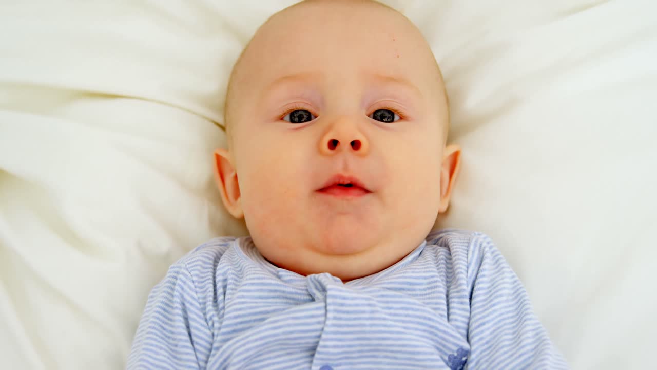 아기 침대 4k에서 휴식을 취하는 동안 웃는 아기 소년