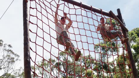 military troops climbing a net during obstacle course 4k