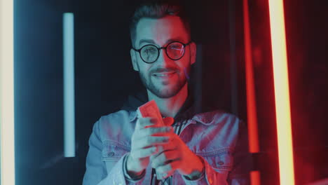 happy man holding cash in neon lights