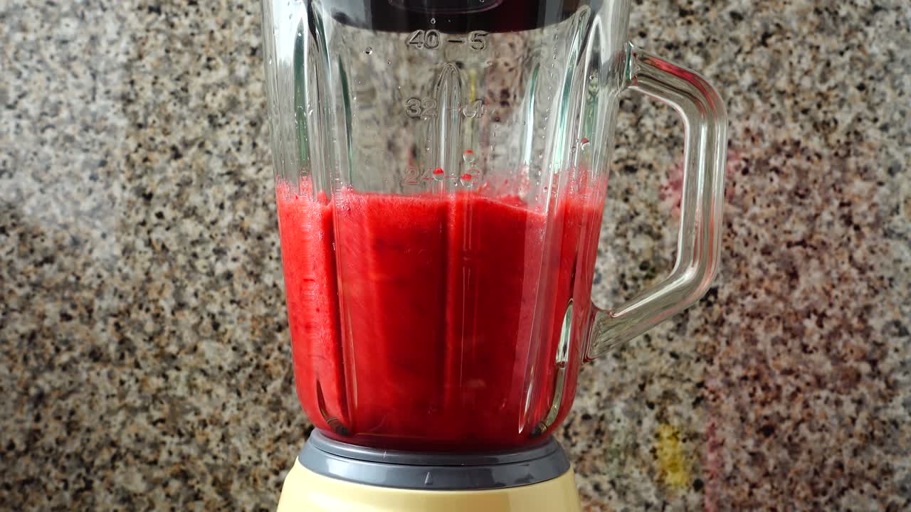 Preparazione nel frullatore di mele, lamponi e banane. Preparazione di frullato nel frullatore