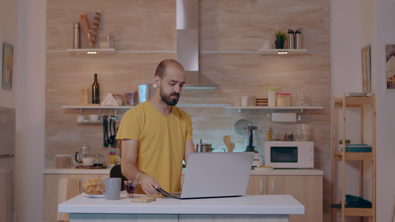 joven entrando en la cocina con un móvil dando comandos de voz