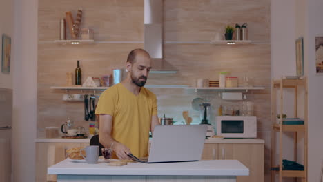 joven entrando en la cocina con un móvil dando comandos de voz